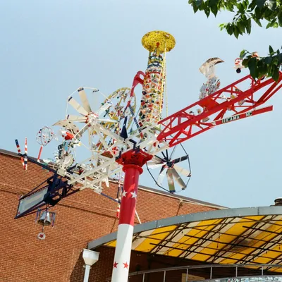 A colorful whirligig folk art sculpture against a blue sky