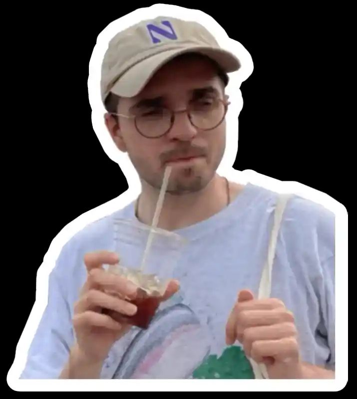 Me with a cap holding an iced coffee cup and winking