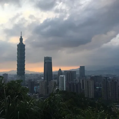 Taipei skyline at dusk with Taipei 101 silhouetted against a dramatic stormy sunset