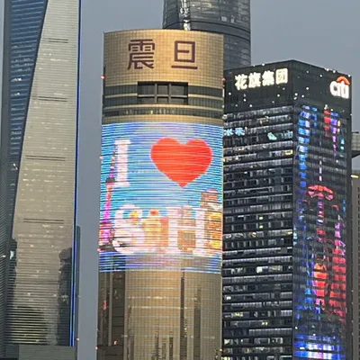 Giant LED screen on a Shanghai skyscraper displaying an "I Love Shanghai" graphic at dusk