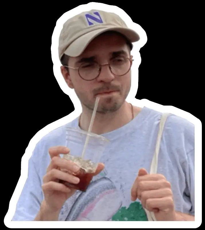 Me with a cap holding an iced coffee cup and winking