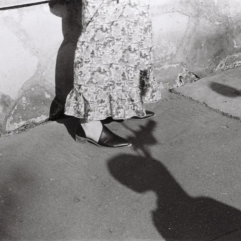 Black and white photo of a woman's legs in flower-pattern pants