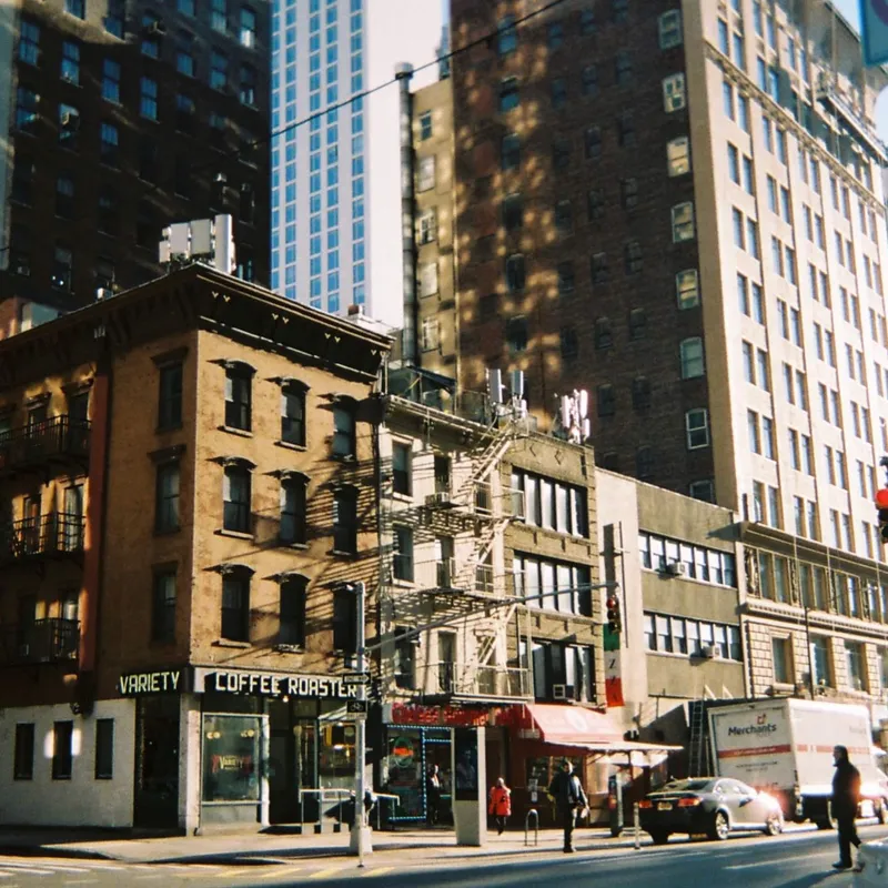 Variety Coffee Roasters on a sunlit NYC street corner with fire escapes