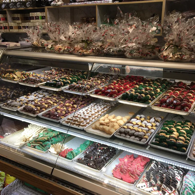 Bakery display case filled with colorful assorted Italian cookies and holiday treats