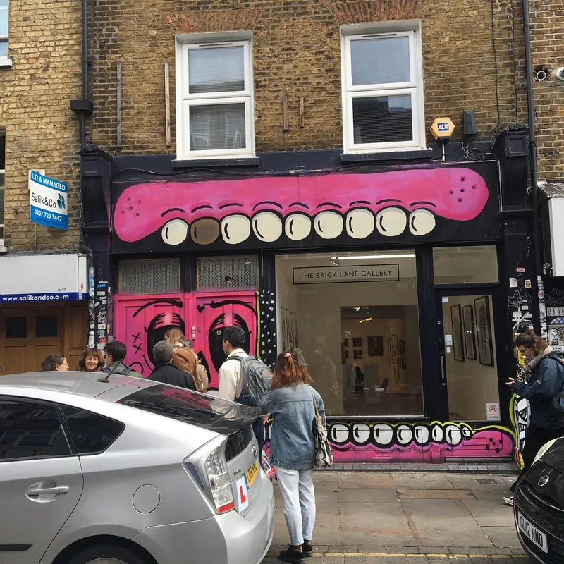 The Brick Lane Gallery storefront with bold pink monster mouth street art