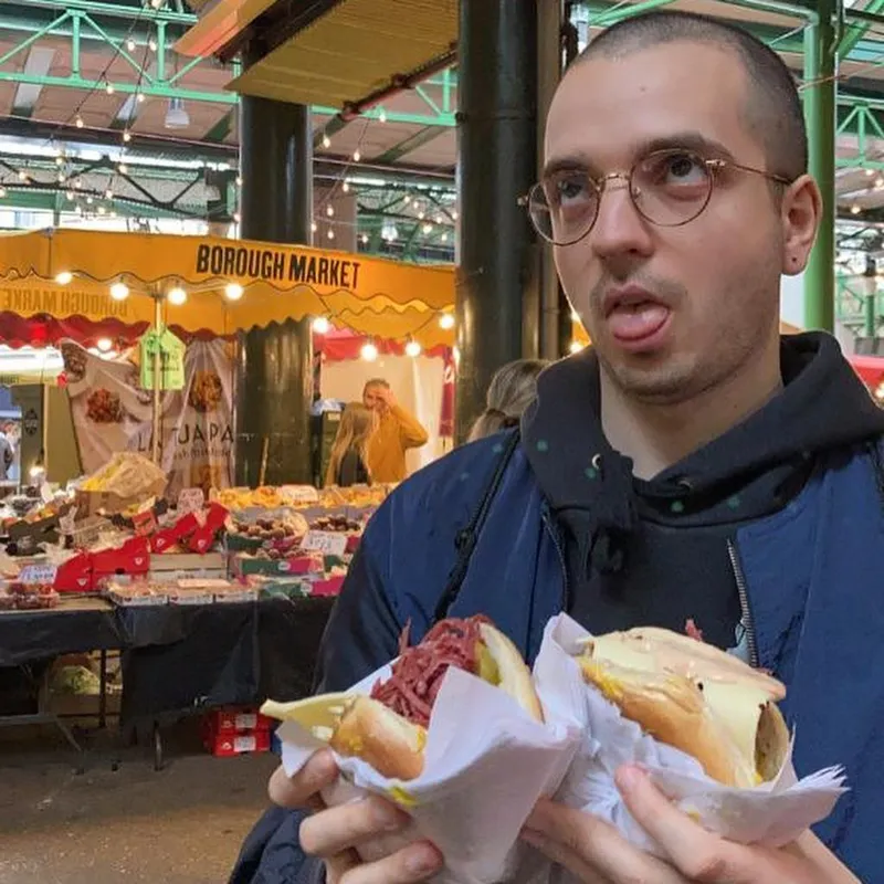 A man holding two salt beef sandwiches at Borough Market in London