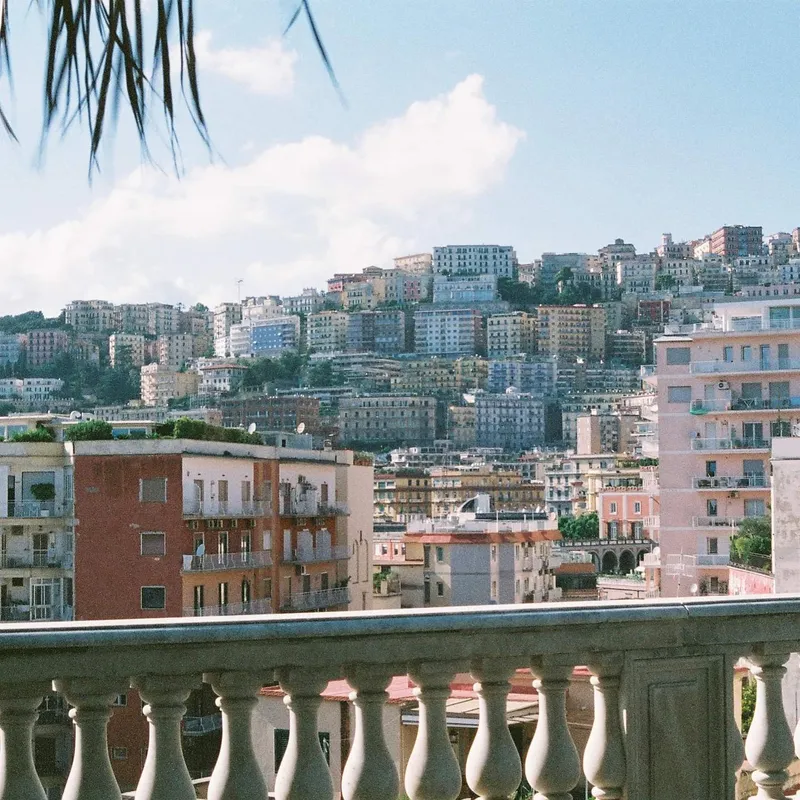 Dense colorful apartment buildings climbing a hillside in Naples
