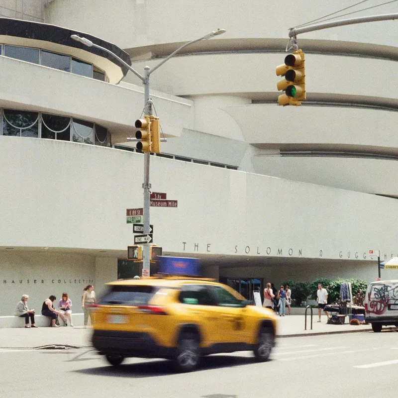 A yellow taxi blurs past the Guggenheim Museum on Fifth Avenue Museum Mile in New York City