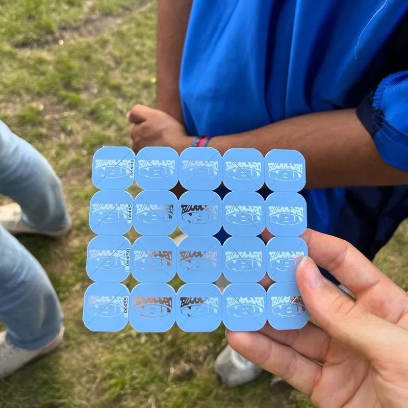 A hand holding a sheet of blue festival tokens