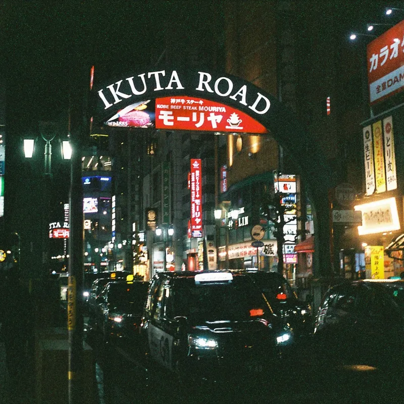The illuminated Ikuta Road entrance arch at night in Kobe