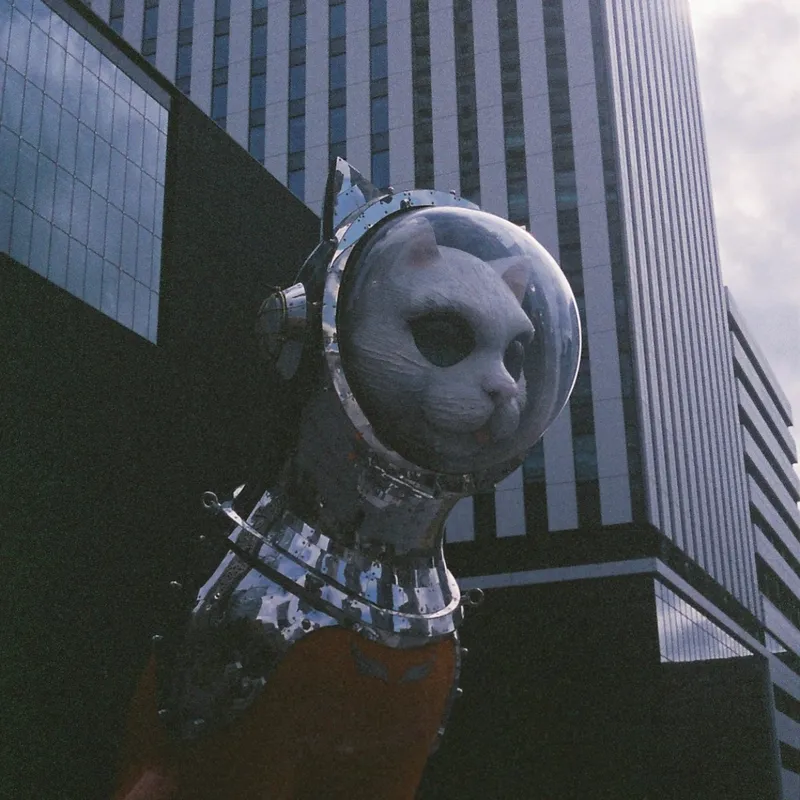 A large metallic sculpture of a cat in an astronaut suit with a glass helmet