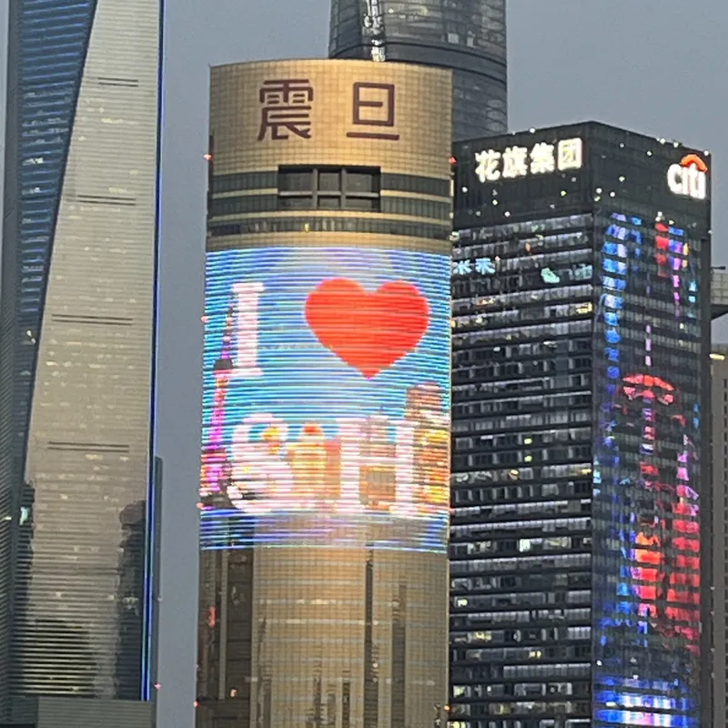Giant LED screen on a Shanghai skyscraper displaying an "I Love Shanghai" graphic at dusk