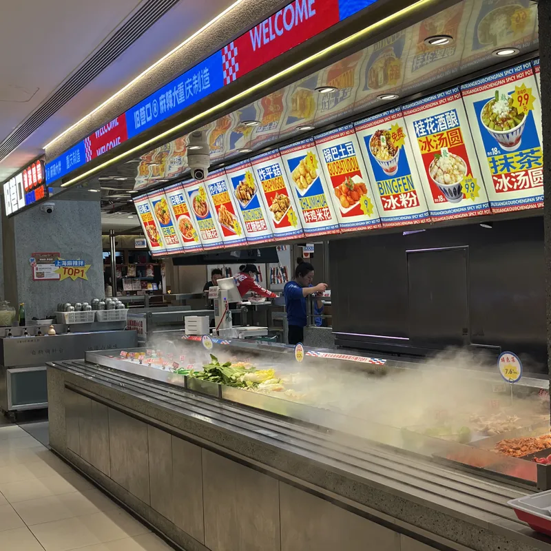 A steaming Chongqing spicy hot pot food stall inside a Chinese shopping mall
