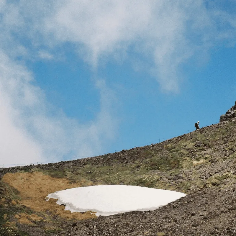 A hiker climbing a rocky slope in the Daisetsuzan volcanic massif in Hokkaido